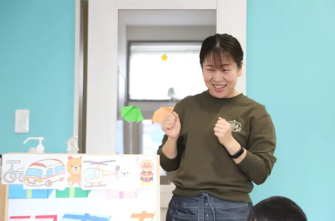 スタッフが絵カードを使って子どもに説明している様子