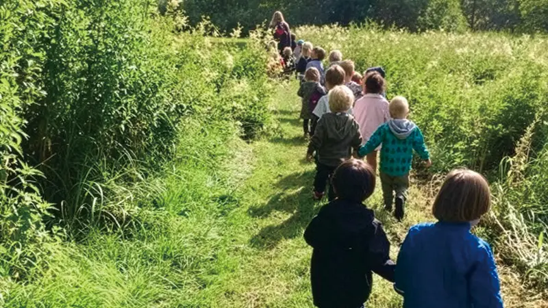 子どもが列になって歩いている画像