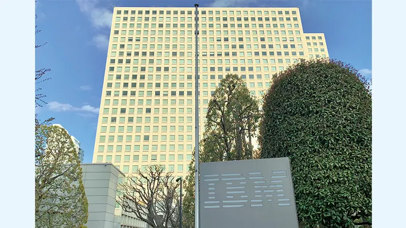 オフィスビル前の階段に座るビジネスマン