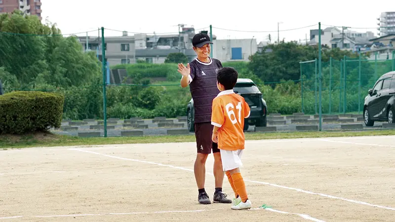 平野氏と子どもがハイタッチする場面